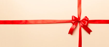 Top view of Red ribbon rolled and red bow isolated on colored background. Flat lay with copy space.の写真素材