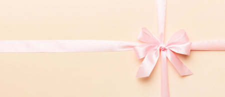 Top view of pink ribbon and bow isolated on colored background. Flat lay with copy space.の写真素材