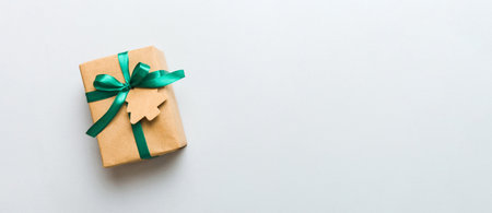 wrapped christmas or other holiday handmade present in paper with colored ribbon. Present box, decoration of gift on colorful table, top view with copy space.の写真素材