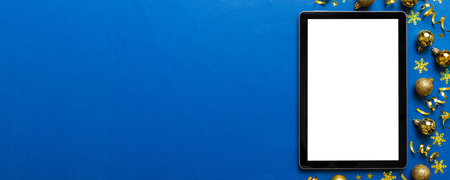 Christmas online shopping from home tablet pc with blank white display top view. Tablet with copy space on colored background with Christmas decorations balls,. Winter holidays sales background.の写真素材