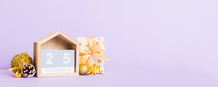 25 december. Christmas composition on colored background with a wooden calendar, with a gift box,...