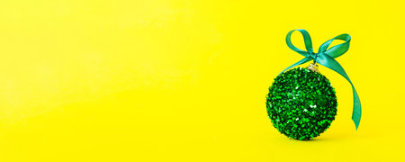 Christmas ball on colored background. decoration bauble with ribbon bow with copy space.