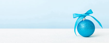 Christmas ball on colored background. decoration bauble with ribbon bow with copy space.の写真素材