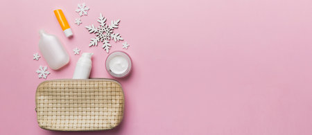 Christmas flat lay with makeup cosmetic products in cosmetic bag on colored background. Top view New...