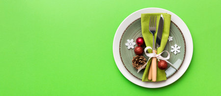 Christmas table place setting with christmas decor and plates, fork and spoon. Christmas holiday background. Top view with copy space.の写真素材