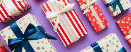 A lot of Christmas gift boxes in colored paper decorated on table, Top view close up. Many present...