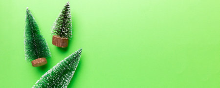Flat lay composition with christmas trees on color background. Top view with copy space.