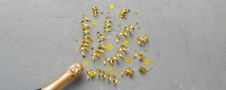 Creative flat lay composition with bottle of champagne and space for text on color background. Champagne bottle with colorful party streamers. holiday or christmas concept.の写真素材