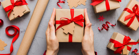 Woman hands holding gift box, preparing surprise for holiday, top view, Christmas and New Year...