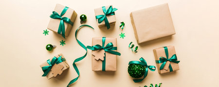 Christmas kraft gifts box with ribbon on colored background. Cozy Christmas still life, birthday or new year.の写真素材