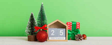 25 december. Christmas composition on colored background with a wooden calendar, with a gift box,...