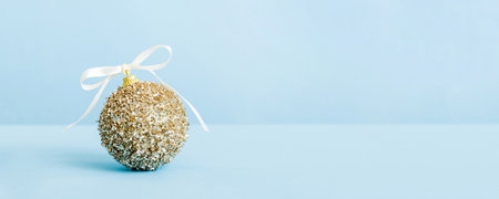 Christmas ball on colored background. decoration bauble with ribbon bow with copy space.