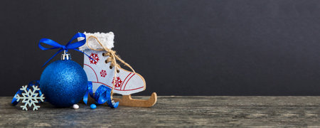 Christmas ball with skates on colored background. decoration bauble with ribbon bow with copy space.の写真素材