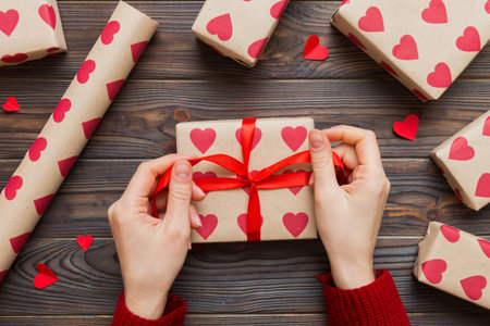 Women hands pack gifts and make decorations for the holiday, top view. Birthday and valentine present.の写真素材
