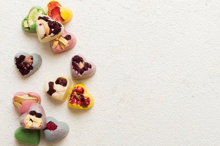 chocolate sweets in the form of a heart with fruits and nuts on a colored background. top view with space for text, holiday concept.の写真素材