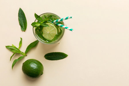 Caipirinha, Mojito cocktail, vodka or soda drink with lime, mint and straw on table background. Refreshing beverage with mint and lime in glass top view flat lay.の写真素材