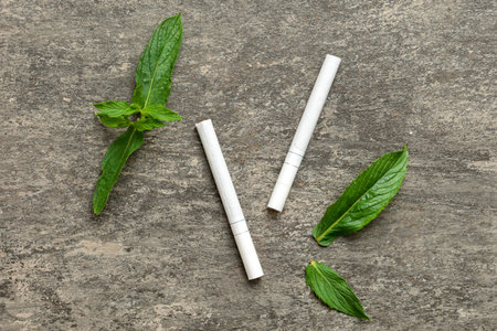 Menthol cigarettes and fresh mint leaves on colored background, Many cigarettes stacked together top view flat lay.の写真素材