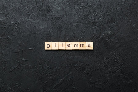 Dilemma word written on wood block. Dilemma text on cement table for your design, concept.の写真素材