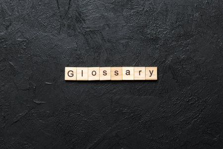 Glossary word written on wood block. Glossary text on cement table for your design, Top view concept.の写真素材