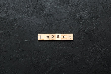 impact written word on wood block. impact text on table, concept.の写真素材