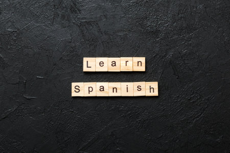learn spanish word written on wood block. learn spanish text on table, concept.の写真素材