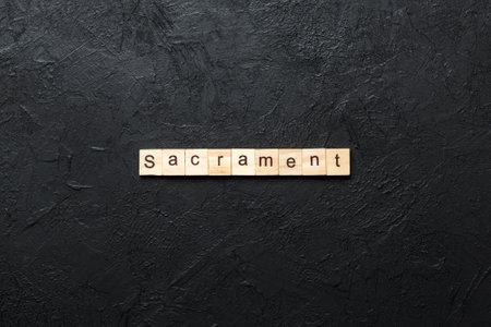 sacrament word written on wood block. sacrament text on table, concept.
