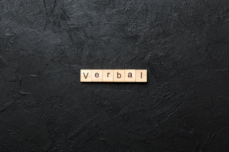 verbal written word on wood block. verbal text on table, concept.