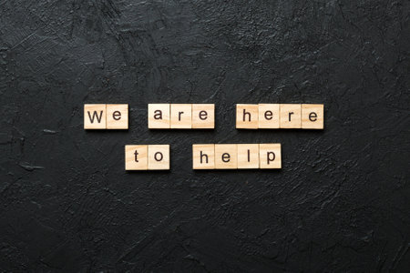 we are here to help word written on wood block. we are here to help text on table, concept.の写真素材