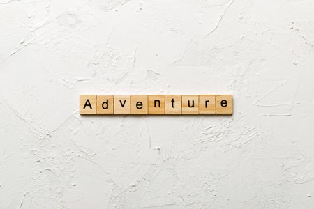 adventure written word on wood block. adventure text on cement table for your design, concept.の写真素材