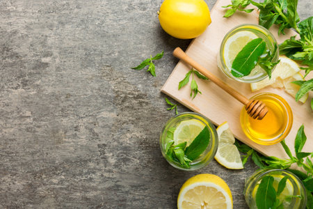Caipirinha, Mojito cocktail, vodka or soda drink with lime, mint and straw on table background. Refreshing beverage with mint and lime in glass top view flat lay.の写真素材