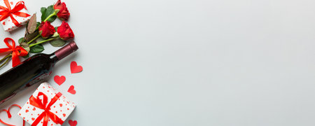 Valentine's day composition with red wine, rose flower and gift box on table. Top view, flat lay. Holiday concept.の写真素材