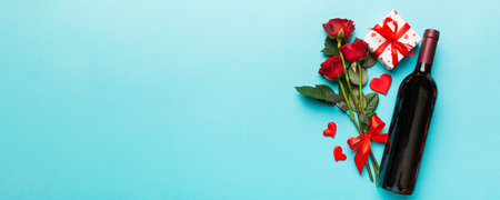 Valentine's day composition with red wine, rose flower and gift box on table. Top view, flat lay. Holiday concept.の写真素材