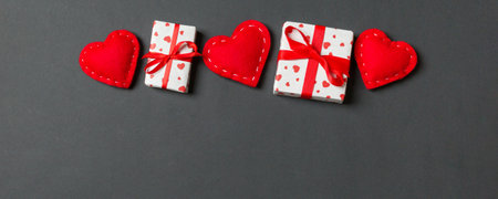 Holiday composition of gift boxes and red textile hearts on colorful background with empty space for your design. Top view of Valentine's Day concept.の写真素材