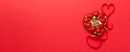 Delicious chocolate pralines in red box for Valentine's Day. Heart shaped box of chocolates top view with copy space.の写真素材