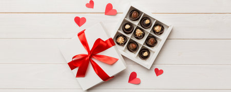 Delicious chocolate pralines in red box for Valentine's Day. Heart shaped box of chocolates top view with copy space.の写真素材