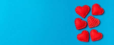 Composition of textile red hearts on colorful background with empty space for your design. Top view...