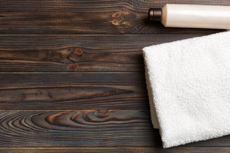 Cosmetic shampoo bottle mockup with towels on a colored table. Bathroom background, toilet accessories for hand and body care.の写真素材