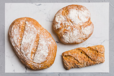 Assortment of freshly baked bread with napkin on rustic table top view. Healthy unleavened bread.の写真素材