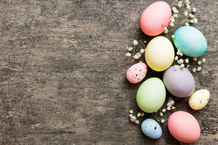 Happy Easter composition. Easter eggs on colored table with gypsophila. Natural dyed colorful eggs background top view with copy space.の写真素材