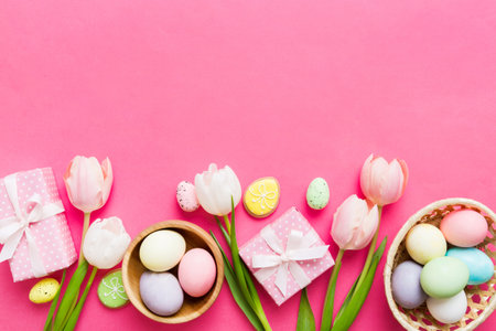 Easter frame with eggs, gift box and tulip on a colored background. The minimal concept. Top view Happy Easter composition. Card with a copy space of the place for the text.の写真素材