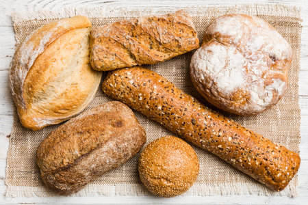 Assortment of freshly baked bread with napkin on rustic table top view. Healthy unleavened bread.の写真素材