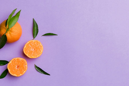 Many fresh ripe mandarin with green leaves on colored background, top view, space for text.の写真素材