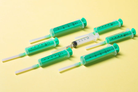 Top view of different syringes at yellow background. Medical injection concept with copy space.の写真素材