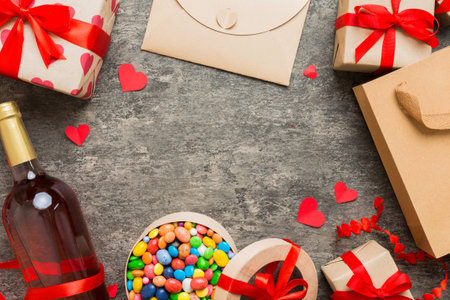 top view photo of st valentine day decor shopping, bag, wine, bottle, envelope, gift, box, candy and red heart on colored background with empty space. frame background.の写真素材