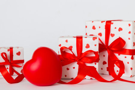 gift box with red bow and red heart on colored background. perspective view. flat lay.の写真素材