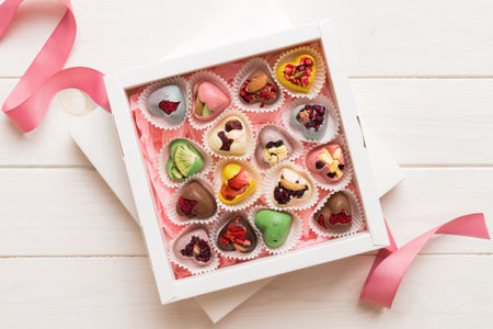 Holiday composition: sweet candy, with gift boxes with bow and chocolate hearts, photo template, background. Top View with copy space on colored background.の写真素材