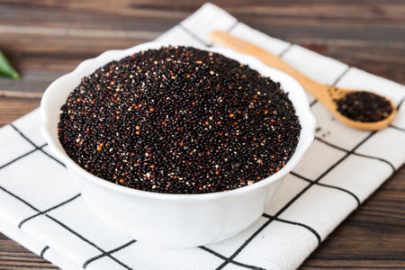 quinoa seeds in bowl and spoon on colored background. Healthy kinwa in small bowl. Healthy superfood.の写真素材