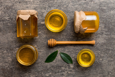Honey jar with wooden honey dipper on white background top view with copy space.の写真素材