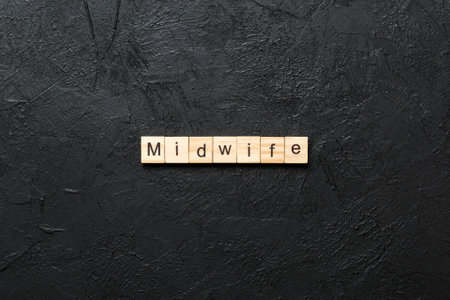 Midwife word written on wood block. Midwife text on table, concept.の写真素材