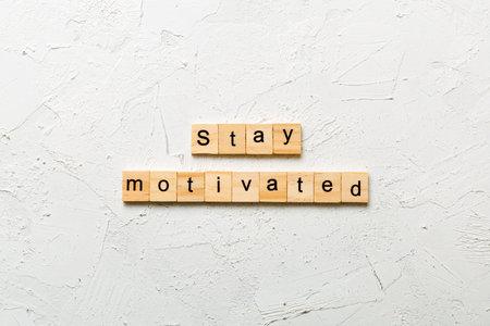 Stay motivated word written on wood block. Stay motivated text on cement table for your design, concept.の写真素材